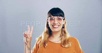 Buy stock photo Portrait, peace sign and woman in studio, glasses and feedback on blue background. Face, happy person and model with hand gesture, support and agreement with symbol, good vibes and emoji with review