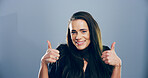 Portrait, thumbs up and woman in studio, thank you and confidence on gray background. Face, person and model with hand gesture, agreement and icon with symbol, promote and like with emoji and review