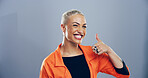 Portrait, thumbs up and woman with symbol, feedback and confidence on gray studio background. Face, person and model with gesture, agreement and icon with review, perfect and like with emoji or great