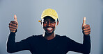 Happy, black man or portrait with thumbs up for well done, success or winning on a gray studio background. Face, male person or model with smile, like emoji or yes sign for approval on mockup space