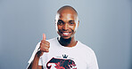 Happy man, portrait or success with thumbs up for good job or positive feedback on a gray studio background. Face, male person or model with smile, like emoji or yes sign for approval on mockup space