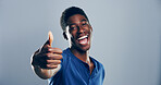 Happy, black man and portrait with thumbs up for winning, success or good job on a gray studio background. Face, male person or model with smile, like emoji or yes sign for approval on mockup space