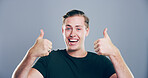 Happy man, portrait and success with thumbs up for approval or good job on a gray studio background. Face, male person or model in joy with smile, like emoji or yes sign for winning or thank you