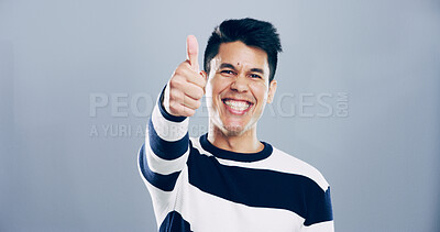 Buy stock photo Portrait, thumbs up and man in studio, smile and confidence on gray background. Face, happy person and model with hand gesture, agreement and icon with symbol, perfect and like with emoji and review