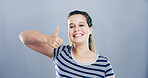 Portrait, thumbs up and woman with like, feedback and confidence on gray studio background. Face, happy person or model with hand gesture, agreement and icon with symbol, perfect or emoji with review