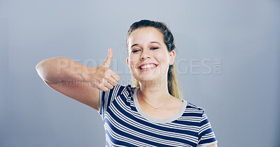 Buy stock photo Portrait, thumbs up and woman with like, feedback and confidence on gray studio background. Face, happy person or model with hand gesture, agreement and icon with symbol, perfect or emoji with review