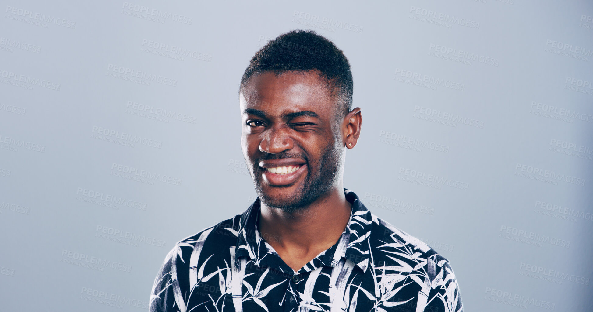 Buy stock photo Black man, happy and face with wink in studio portrait, sign or emoji for secret, flirt or joke by background. Person, model and smile with icon, style and eye symbol by space with pride in Nigeria