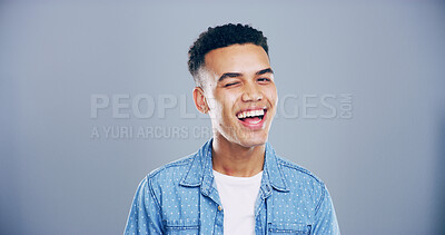Buy stock photo Man, happy and wink in studio portrait, confident and flirt with emoji, space and eye symbol by background. Person, model and smile with sign, icon and laugh with secret, deal or joke in Colombia