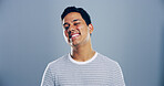 Man, happy and space with wink in studio portrait, sign and emoji for secret, flirt and attitude by background. Person, confidence and smile with icon, playful and eye symbol with pride in Mexico