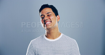 Buy stock photo Man, happy and space with wink in studio portrait, sign and emoji for secret, flirt and attitude by background. Person, confidence and smile with icon, playful and eye symbol with pride in Mexico