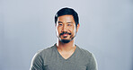Studio, man and portrait with smile for wink, emoji expression and carefree model with flirting. Male person, confidence and goofy with funny personality, secret and mockup space by gray background