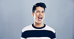 Studio, man and portrait with wink for playful, emoji expression or carefree model with flirting. Male person, mouth or goofy with silly personality for mood, crazy or mockup space by gray background