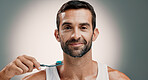 Smile, portrait and man brushing teeth on studio background for fresh breath, grooming or oral hygiene. Mockup space, morning routine or cleaning mouth for cavity prevention, plaque removal or health