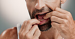 Mouth, teeth and man with dental floss on studio background for oral hygiene, plaque removal and self care. Closeup, person and cleaning with thread for fresh breath, cavity prevention and grooming