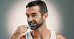 Oral hygiene, portrait and man brushing teeth on studio background for fresh breath, grooming and self care. Mockup space, morning routine and cleaning mouth for cavity prevention and plaque removal