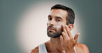 Application, face cream and portrait of man in studio for wellness, health and hydration for facial care. Dermatology, beauty and person with lotion, moisturizer or skincare on gradient background