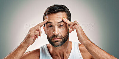 Buy stock photo Man, face check and portrait in studio for skincare, wellness or cosmetics with space for antiaging. Male person, model and inspection for wrinkles, beauty treatment or forehead on gray background