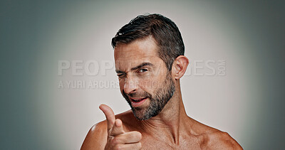 Buy stock photo Skincare, wink and portrait of man in studio pointing to you for facial, beauty and wellness. Health, dermatology and person with choice gesture for cosmetics, grooming and spa on gradient background