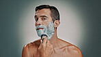 Shaving, cream and brush with portrait of man in studio for beard grooming, beauty and cleaning. Hair removal, cosmetics and self care with person and foam on background for hygiene and skincare