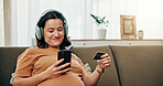 Happy, pregnant woman and phone with credit card for online shopping, maternity ecommerce and payment. Person, headphones and digital with medical expenses, baby items and pregnancy podcast at house