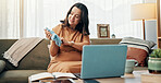 Pregnant, woman and baby clothes for video call, talking and sharing motherhood on social media with laptop. House, influencer and beanie for gender reveal on app, communication and happy for child