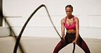 Fitness, outdoor and woman with battle ropes for intense training, workout or health. Muscle, female bodybuilder and equipment for strength exercise, fast and motion blur for cardio challenge in city