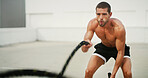 Man, fitness and outdoor with battle ropes, training and strong with challenge for muscle growth. Person, power and body builder with resilience, performance and workout at exercise club in Germany