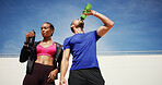 Man, woman and fitness with drinking water in city, sky or hydration for training, health or recovery for wellness. People, couple and partnership with bottle, exercise or workout for break in summer