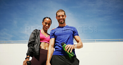 Buy stock photo Couple, smile and fitness with portrait, outdoor and low angle in summer with water, support or space for wellness. Man, woman and happy together for workout, training or bottle for exercise with sky