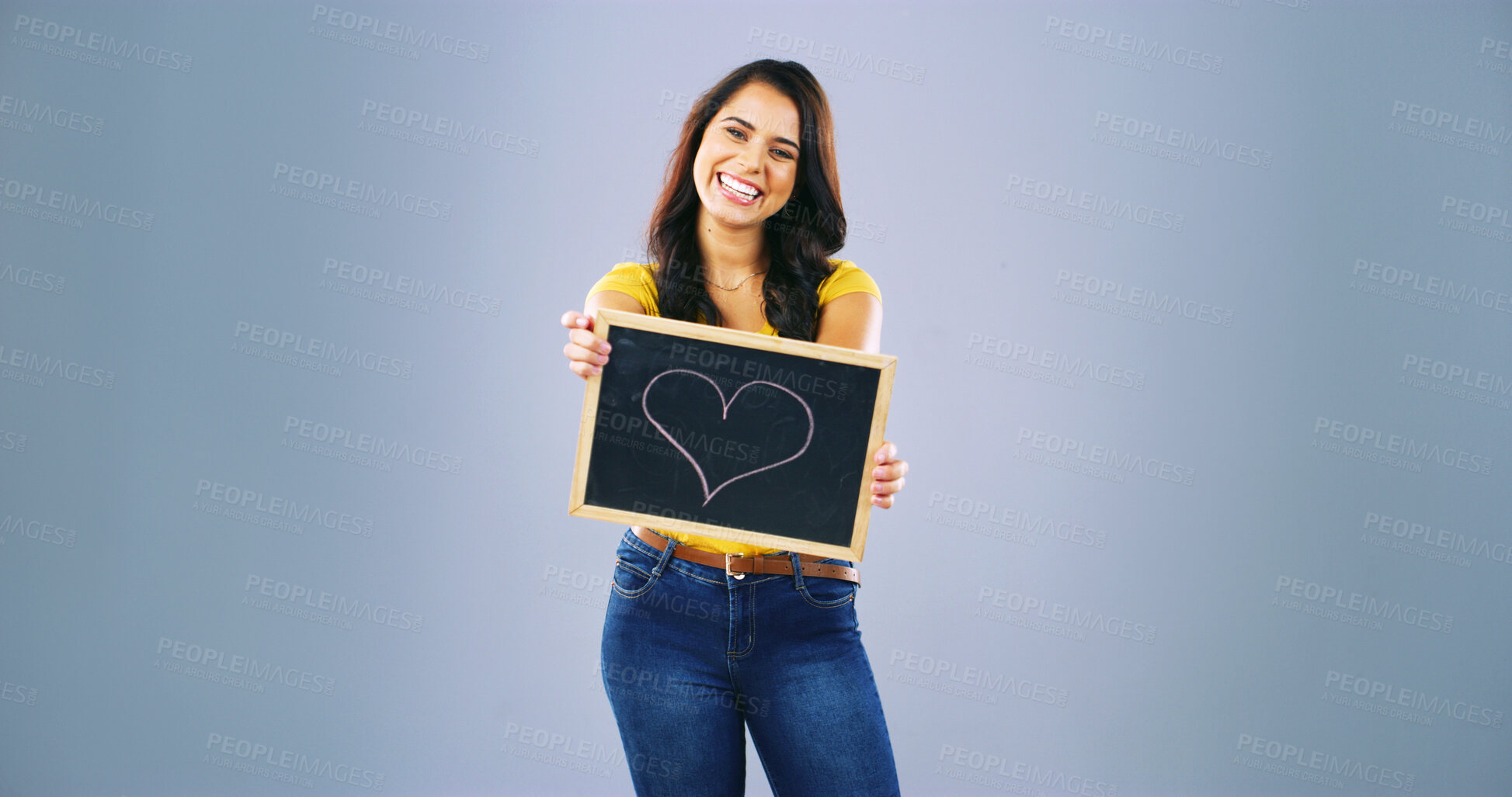 Buy stock photo Portrait, smile and woman with heart on black board of self love, spread kindness and celebrate moments. Person, sign and space for advertising romance, passion and happiness in studio background