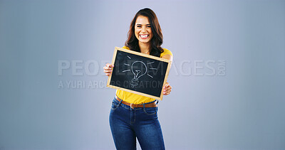 Buy stock photo Woman, portrait and studio background with black board for lightbulb, idea and smile on gray mockup space. Female person, sign and billboard poster for information, news notification or promotion