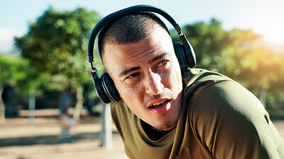 Buy stock photo Fitness, tired and man with headphones at park with running fatigue, workout music or breathing break. Athlete, runner or exhausted in nature with exercise podcast, resting or cardio recovery outdoor