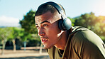 Runner, tired and man with headphones at park with running fatigue, cardio challenge or breathing break. Fitness, athlete or exhausted in nature with resting, sports recovery or workout music outdoor
