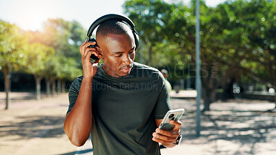 Buy stock photo Fitness, headphones and black man on mobile outdoor for music, streaming subscription or sound. Athlete, phone and listening to radio, exercise podcast or audio for motivation playlist in park