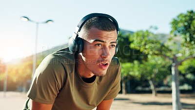 Buy stock photo Runner, tired and man with headphones at park for workout playlist, running fatigue or breathing break. Fitness, athlete or exhausted in nature with exercise music, resting or cardio recovery outdoor