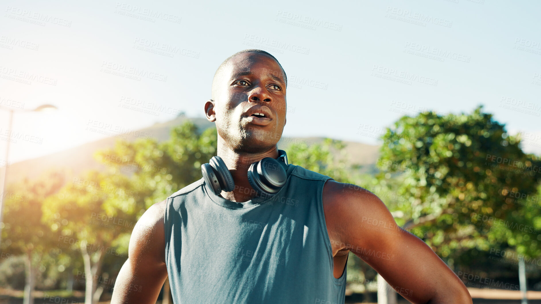 Buy stock photo Fitness, tired and black man with break at park for running fatigue, workout performance and marathon challenge. Athlete, space and headphones in nature for exercise music, resting or cardio recovery