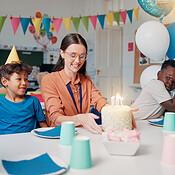 Birthday, cake and children with teacher in classroom for group party ...
