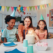 Children, teacher and birthday cake for party in classroom with candles ...