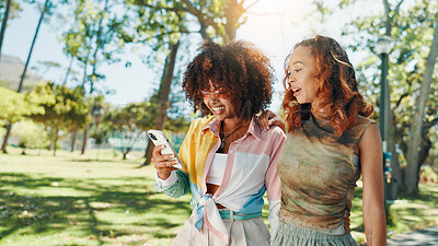 Buy stock photo Happy, women and friends with mobile outdoor for social media post, fashion blog or reading text message. Phone, gen z and girls at park together for online gossip, communication or show video on app