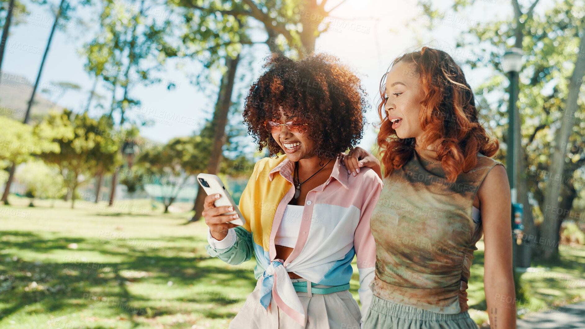 Buy stock photo Happy, women and friends with mobile outdoor for social media post, fashion blog or reading text message. Phone, gen z and girls at park together for online gossip, communication or show video on app