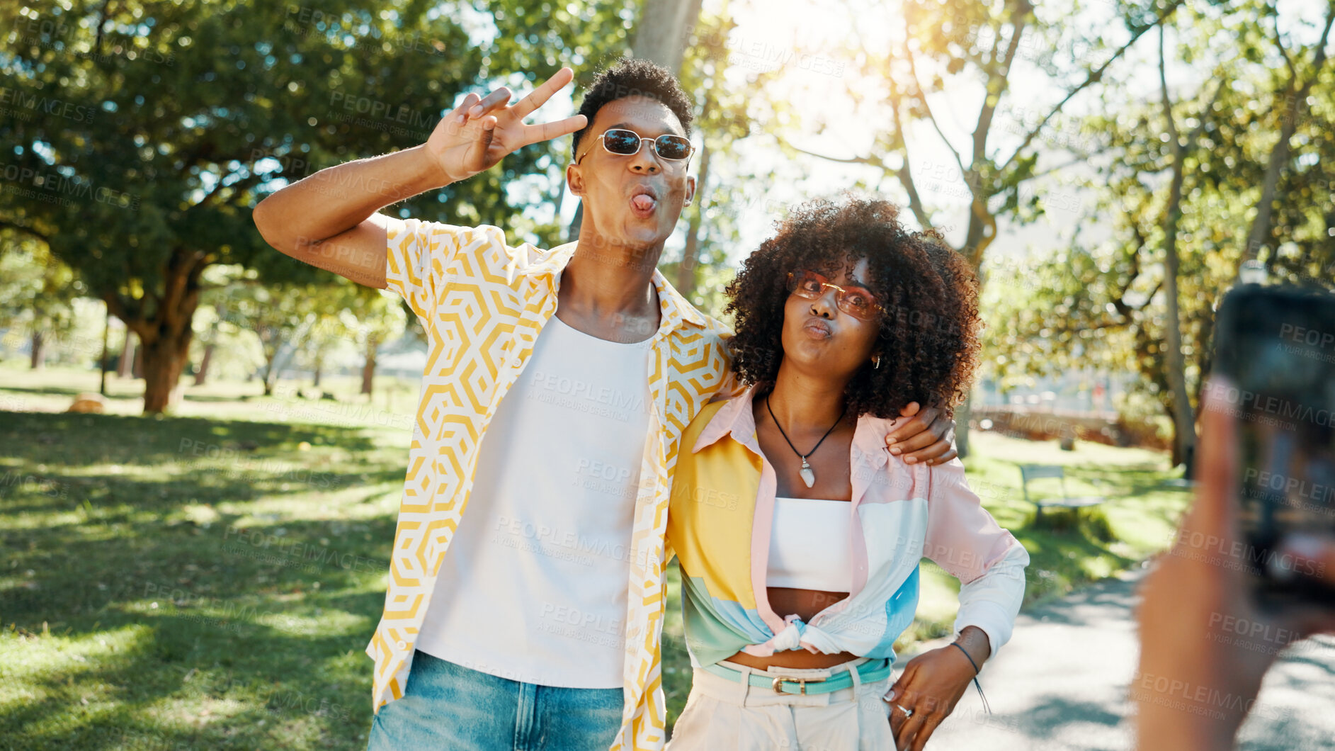 Buy stock photo Fashion, cool and couple in park for photograph together for love, bonding or relationship in summer. Peace sign, social media influencer or men with women in nature for picture, vacation or holiday