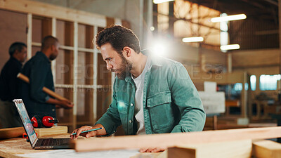 Buy stock photo Carpenter, laptop and research with wood to measure for construction, furniture or project. Woodworker, person and plank with blueprint in creative carpentry workshop for manufacturing, art and craft