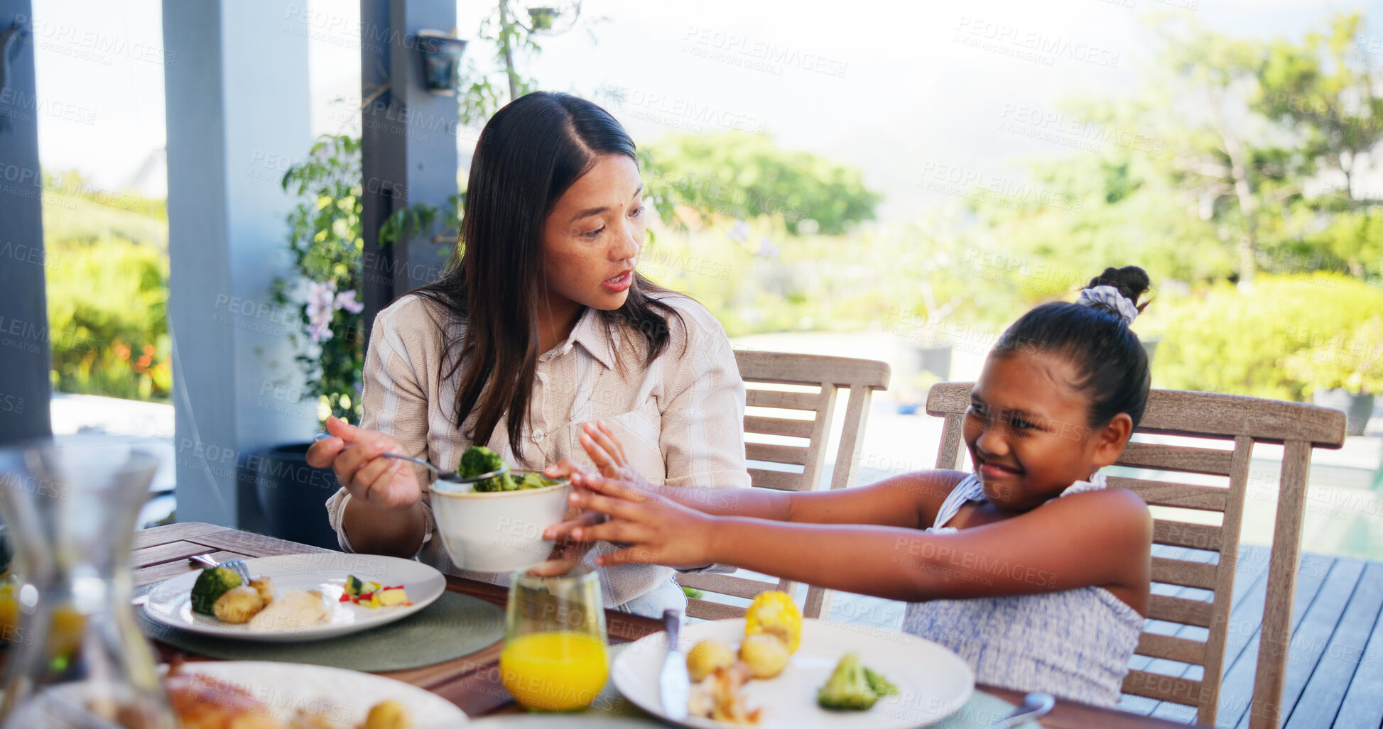 Buy stock photo Vegetables, refuse and mother feeding kid with broccoli, nutrition or healthy lunch at outdoor patio. Family, parent and child reject food or unhappy girl with no for diet, dislike or disgust at home