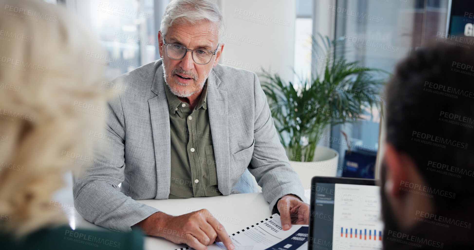 Buy stock photo Office, meeting and businessman with paperwork for discussion, investment briefing and review finance. Team, employees and mature financial advisor with document for feedback, report or laptop screen