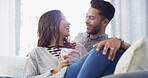 Relax, talking and couple with coffee on sofa for conversation, bonding and happy together. Home, dating and man and woman with drink for relationship, affection and embrace for love in living room