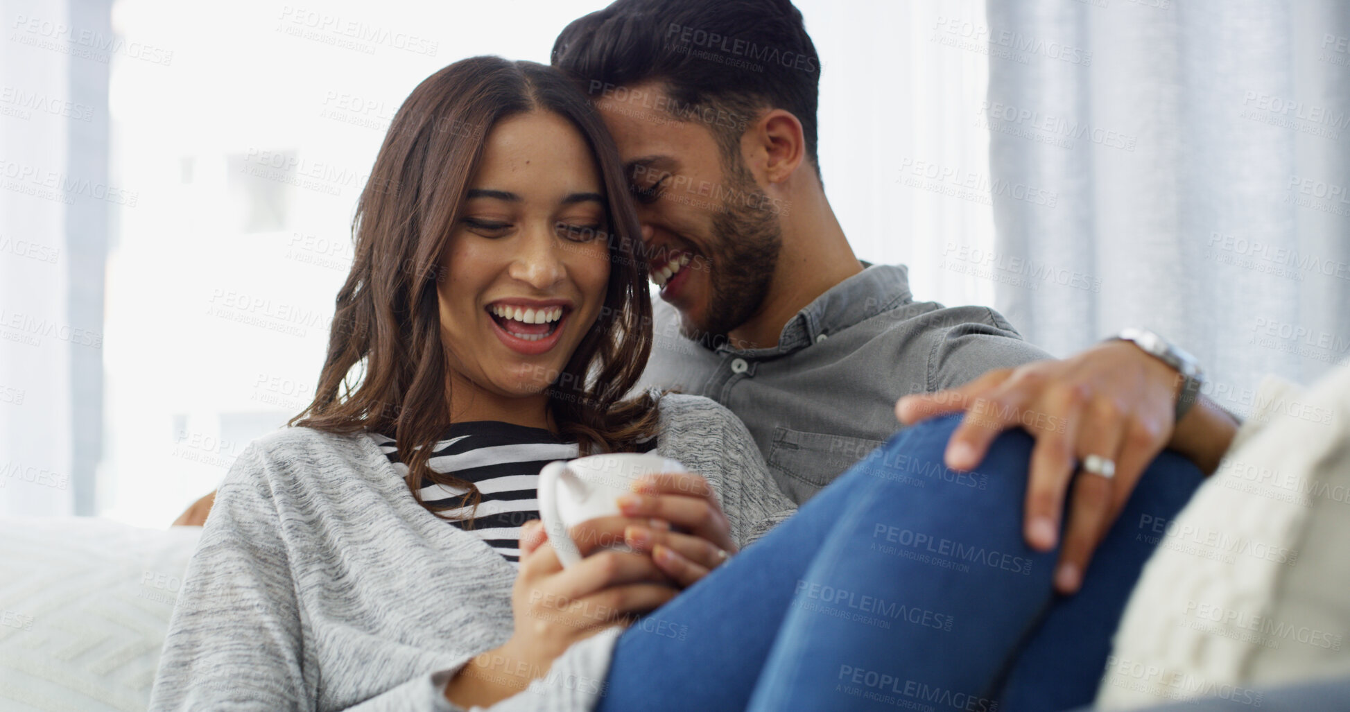 Buy stock photo Laughing, smile and couple with coffee, home and chilling in living room with woman, embrace or love. Happy, man and romance with partner in lounge, tea and comfortable in house, joke or relationship