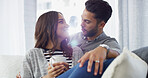 Bonding, smile and couple with coffee, home and chilling in living room with woman, embrace or love. Happy, man and romance with partner in lounge, tea and comfortable in house, relax or relationship