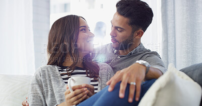 Buy stock photo Bonding, smile and couple with coffee, home and chilling in living room with woman, embrace or love. Happy, man and romance with partner in lounge, tea and comfortable in house, relax or relationship