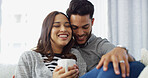 Relax, laughing and couple with coffee, home and love in living room with woman, hug and bonding. Happy, man and romance with partner in lounge, tea and comfortable in house, chilling or relationship