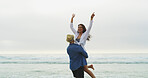 Couple, beach and lift for fun on vacation with honeymoon, holiday or bonding outdoor in nature. Excited woman, man and freedom by sea for memory, playful date and happy with space and energy